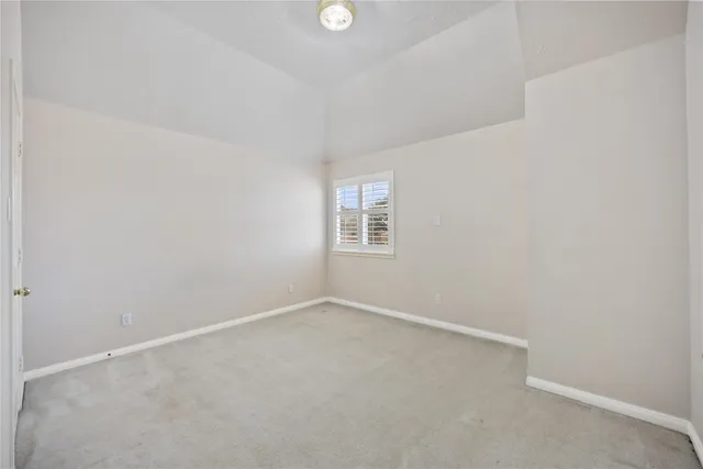 an empty room with a window and a ceiling fan