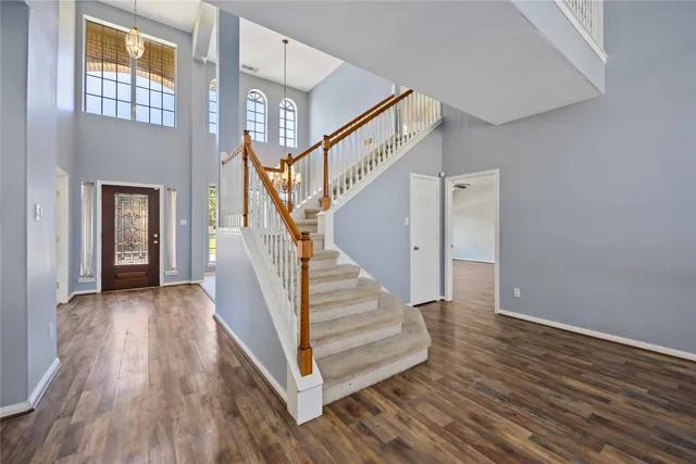 a view of a hallway with wooden floor and staircase
