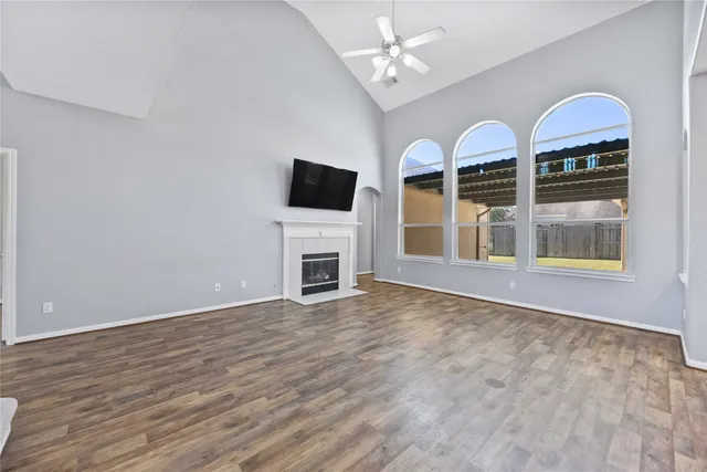 wooden floor fireplace and windows in the room