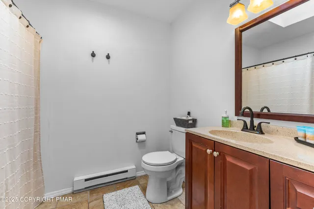 a bathroom with a granite countertop toilet a sink and a mirror