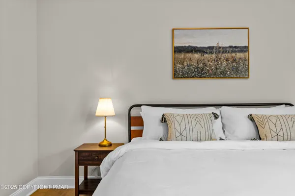 a bedroom with a bed and a lamp with the wall painting