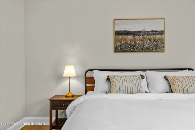 a bedroom with a bed and a lamp with the wall painting