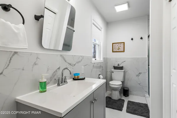 a bathroom with a sink a toilet and shower