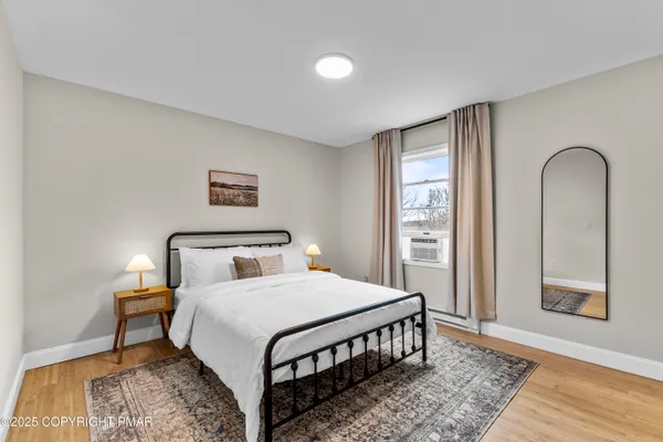 a bedroom with a bed and wooden floor