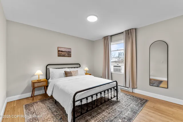 a bedroom with a bed and wooden floor