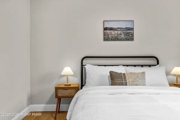 a bedroom with a bed and wooden floor