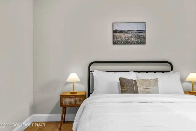 a bedroom with a bed and wooden floor