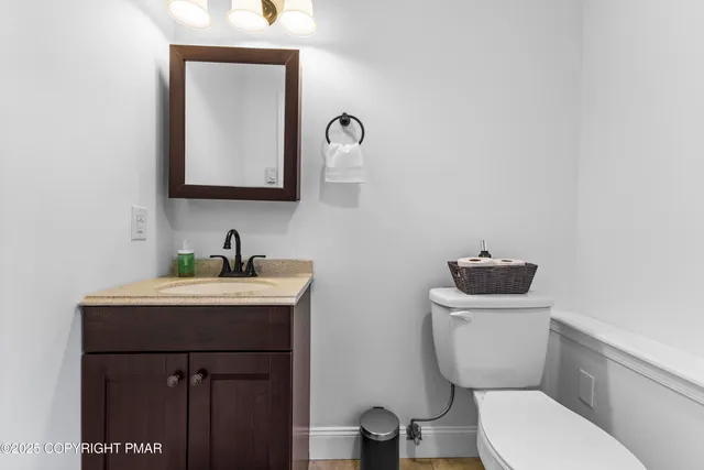 a bathroom with a toilet a sink and mirror