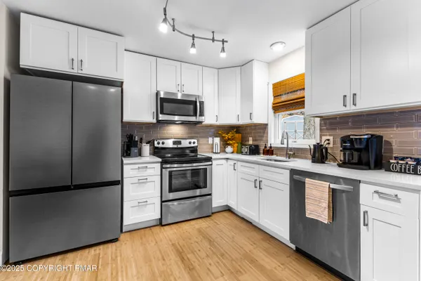 a kitchen with cabinets stainless steel appliances and a window