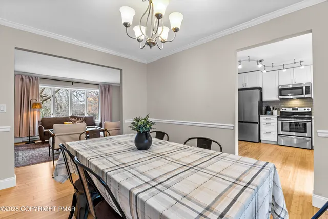 a kitchen with a table chairs stainless steel appliances and cabinets
