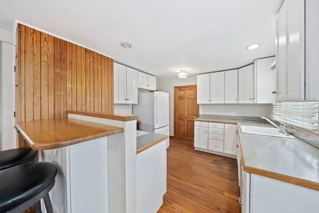 a white toilet sitting next to a bathroom sink and a shower curtain
