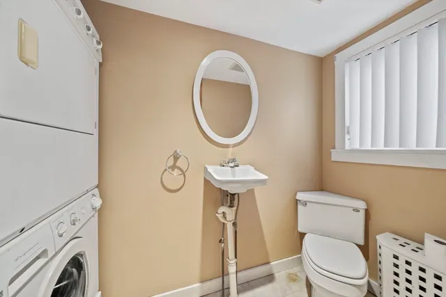 a view of a white house with large windows next to a road