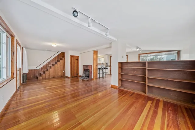 a view of a big room with wooden floor and windows