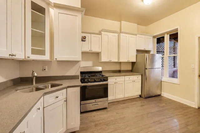 a kitchen with stainless steel appliances granite countertop a refrigerator sink and stove