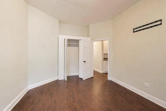 an empty room with wooden floor and a window