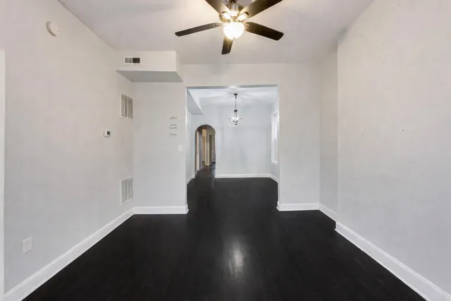 a view of a hallway with wooden floor and a chandelier
