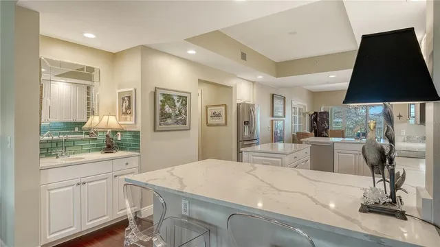 a kitchen with stainless steel appliances kitchen island granite countertop a refrigerator and cabinets