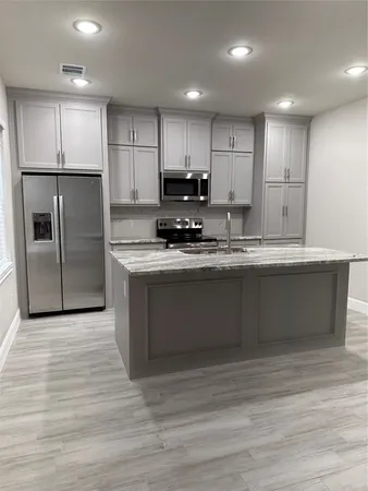 a kitchen with kitchen island white cabinets and stainless steel appliances