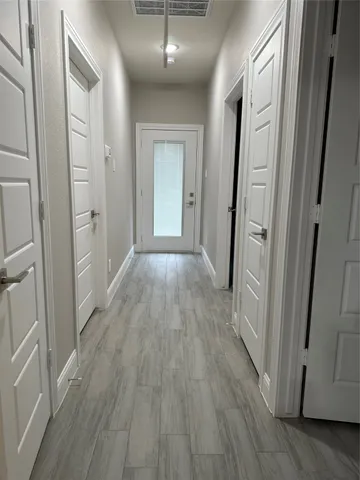 a view of a hallway with wooden floor
