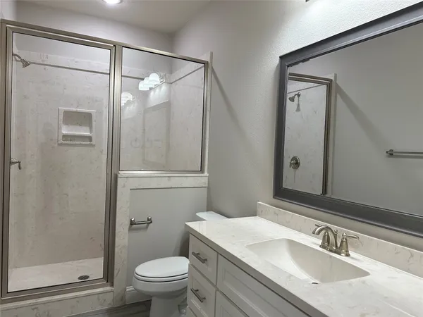 a bathroom with a granite countertop sink toilet and shower