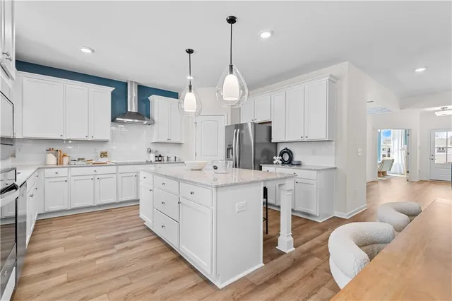 a kitchen with stainless steel appliances granite countertop a sink a stove and a wooden floors