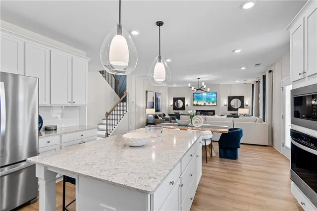 a large kitchen with kitchen island a large counter space a sink appliances and cabinets
