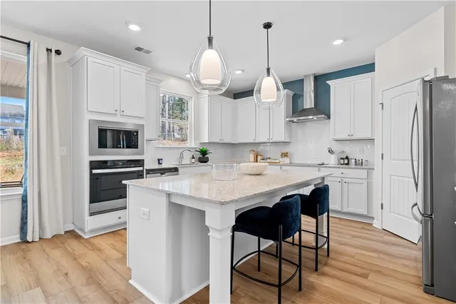a kitchen with stainless steel appliances granite countertop a sink refrigerator and cabinets