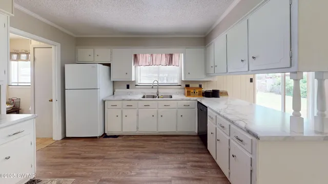 a kitchen with white cabinets and white appliances