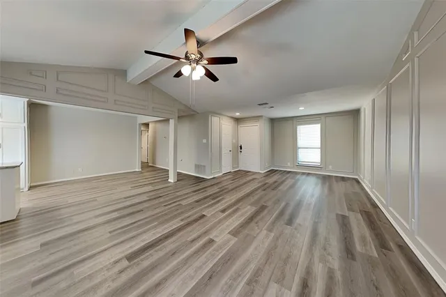 a view of empty room with window and wooden floor