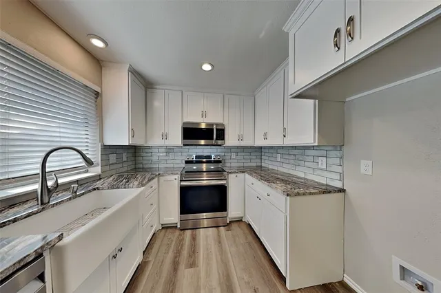 a kitchen with stainless steel appliances cabinets a sink and a stove