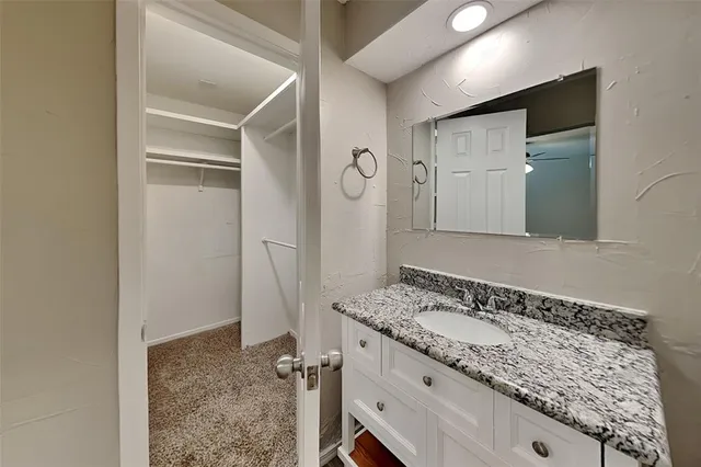 a bathroom with a granite countertop sink and a mirror