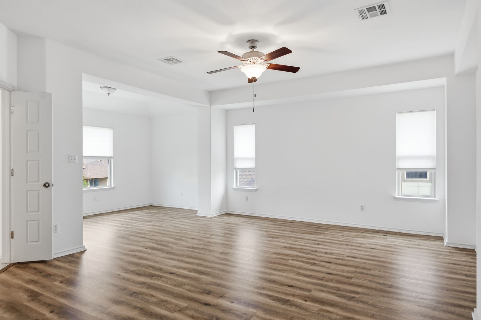 8012 Izetta Lane Austin, TX 78744 - Photo 11 of 27 a view of an empty room with wooden floor and a window