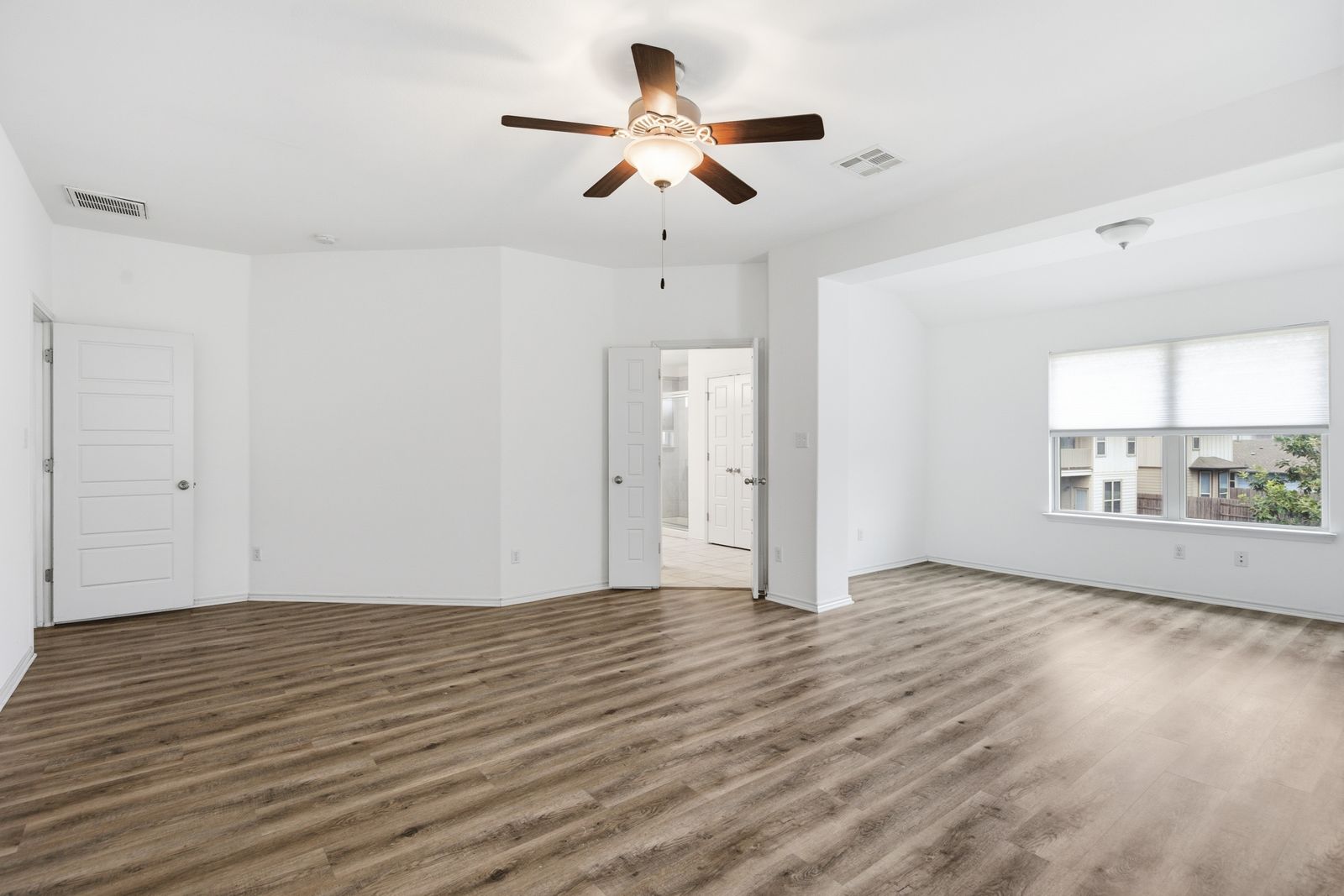 8012 Izetta Lane Austin, TX 78744 - Photo 12 of 27 a view of an empty room with wooden floor and a window