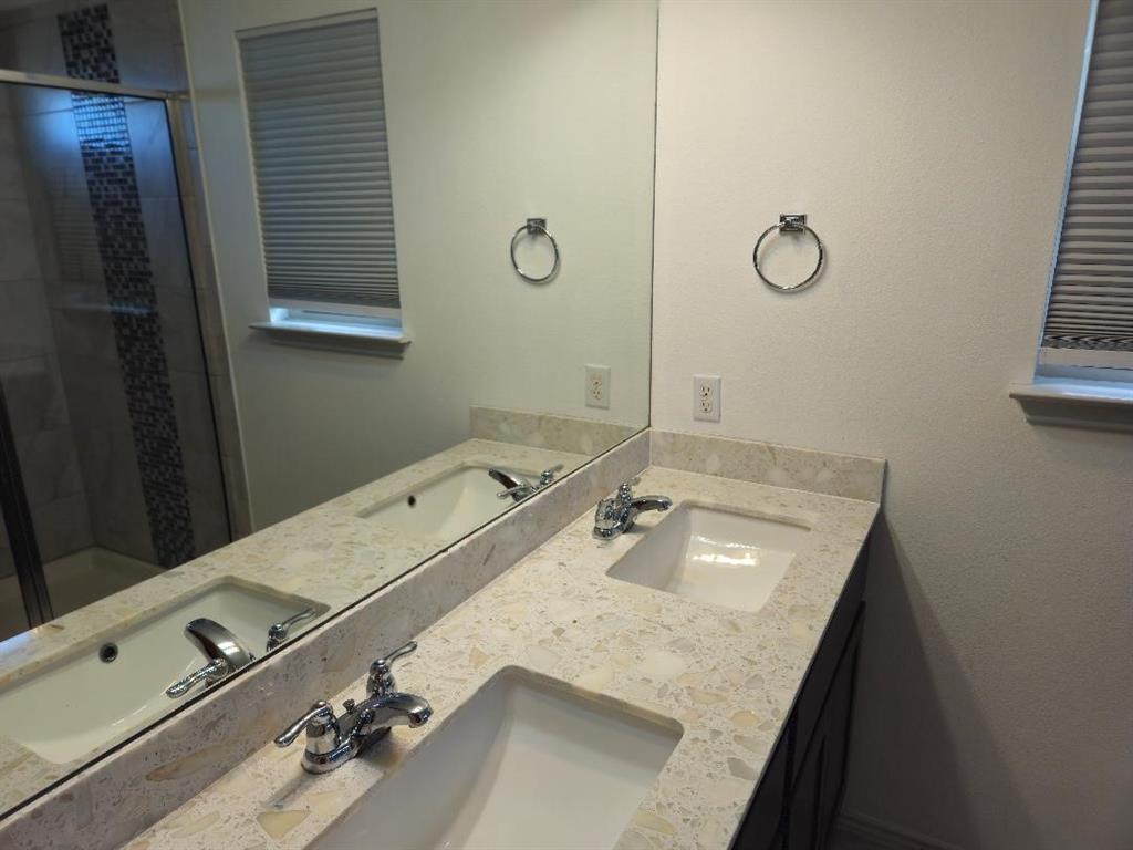 8012 Izetta Lane Austin, TX 78744 - Photo 14 of 27 a bathroom with a granite countertop sink and a mirror