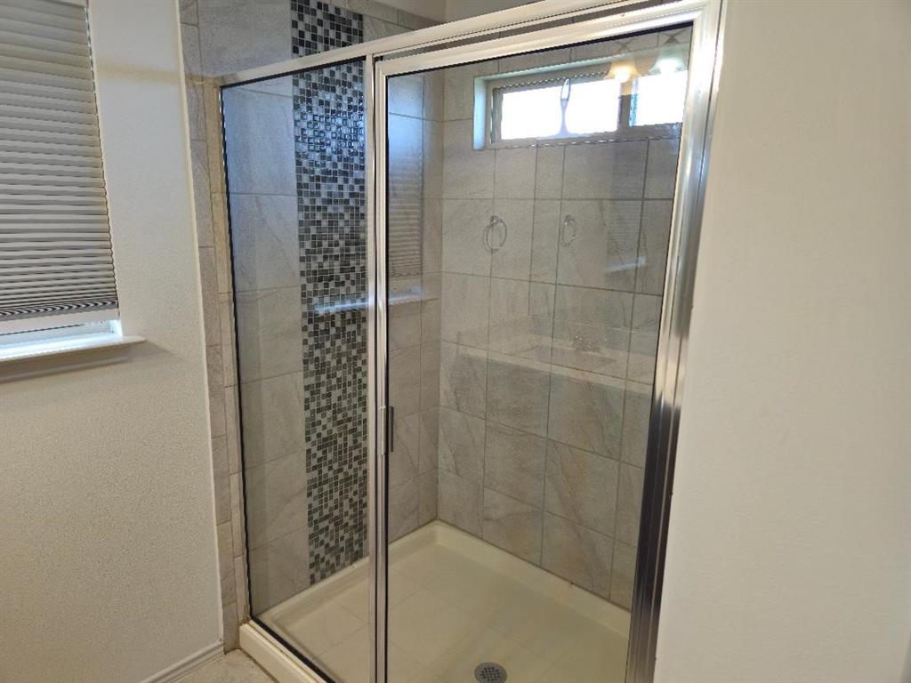 8012 Izetta Lane Austin, TX 78744 - Photo 16 of 27 a bathroom with a glass shower door