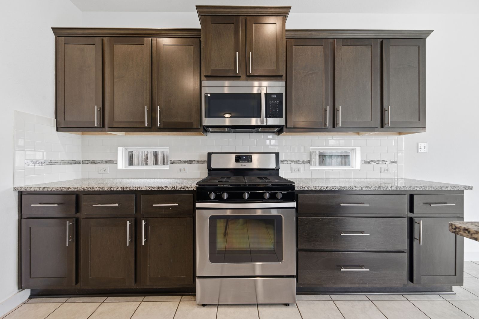 8012 Izetta Lane Austin, TX 78744 - Photo 8 of 27 a kitchen with granite countertop a stove top oven microwave and cabinets