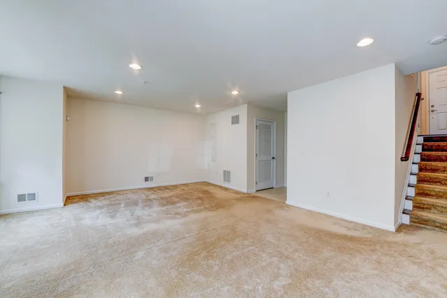 a view of an empty room with stairs and a walk in closet