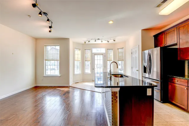 a kitchen with stainless steel appliances granite countertop a refrigerator and a counter top space