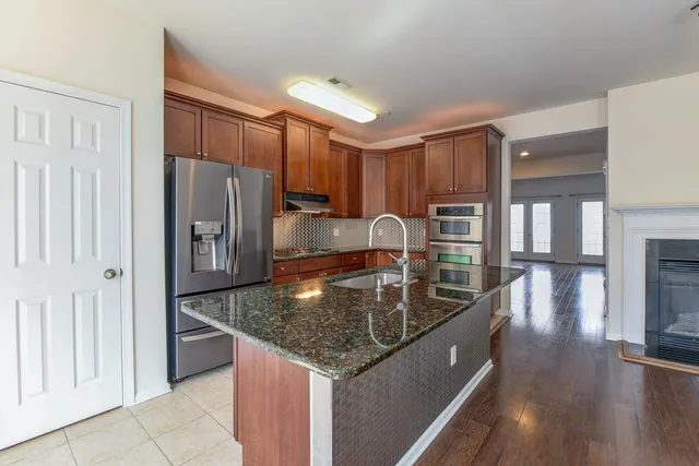 a kitchen with stainless steel appliances granite countertop a sink a refrigerator and a stove