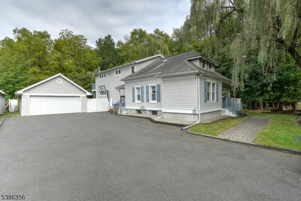 a view of a house with a yard and large tree