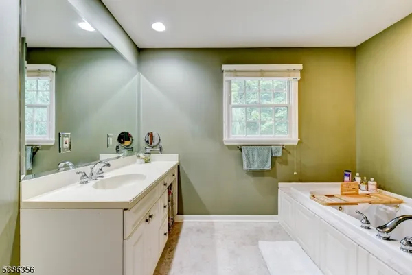 a spacious bathroom with a double vanity sink a mirror and a bathtub