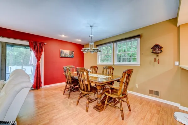 a dining room with furniture a chandelier and wooden floor