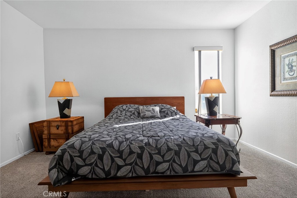 610 Violeta Drive Palm Springs, CA 92262 - Photo 12 of 25 a bedroom with a bed a lamp and a dresser