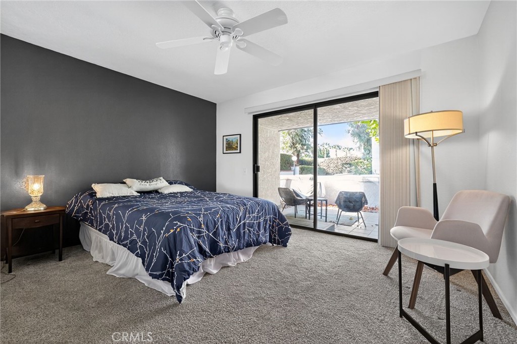 610 Violeta Drive Palm Springs, CA 92262 - Photo 13 of 25 a spacious bedroom with a bed and a chandelier