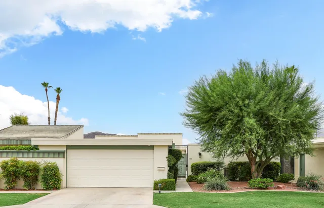 a view of a house with a yard and potted plants