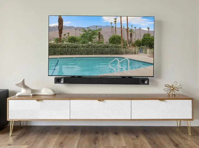 a view of a swimming pool with a lawn chairs and wooden fence