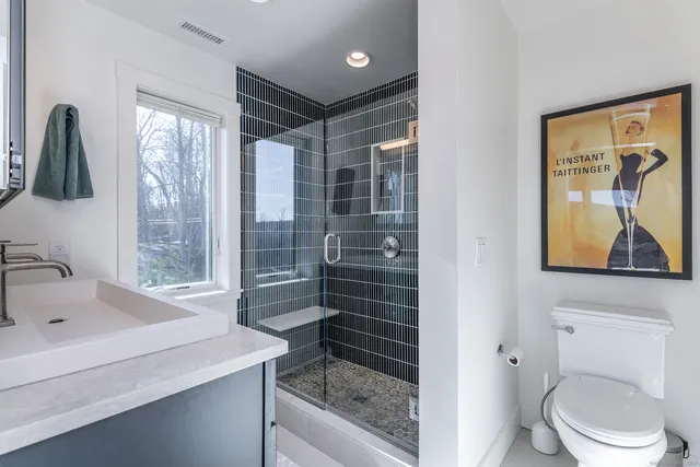 a bathroom with a sink a toilet and shower