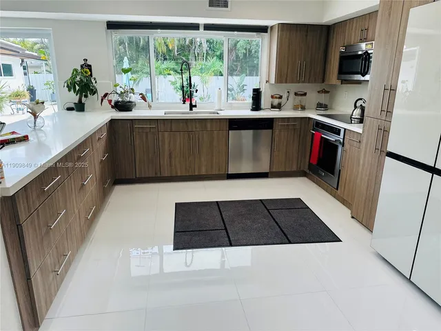 a kitchen with a sink a window and cabinets