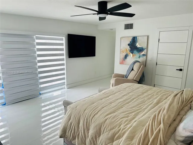 a bedroom with a bed and a flat tv screen
