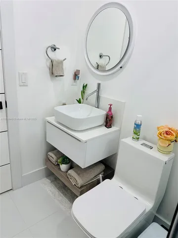 a bathroom with a sink mirror vanity and toilet
